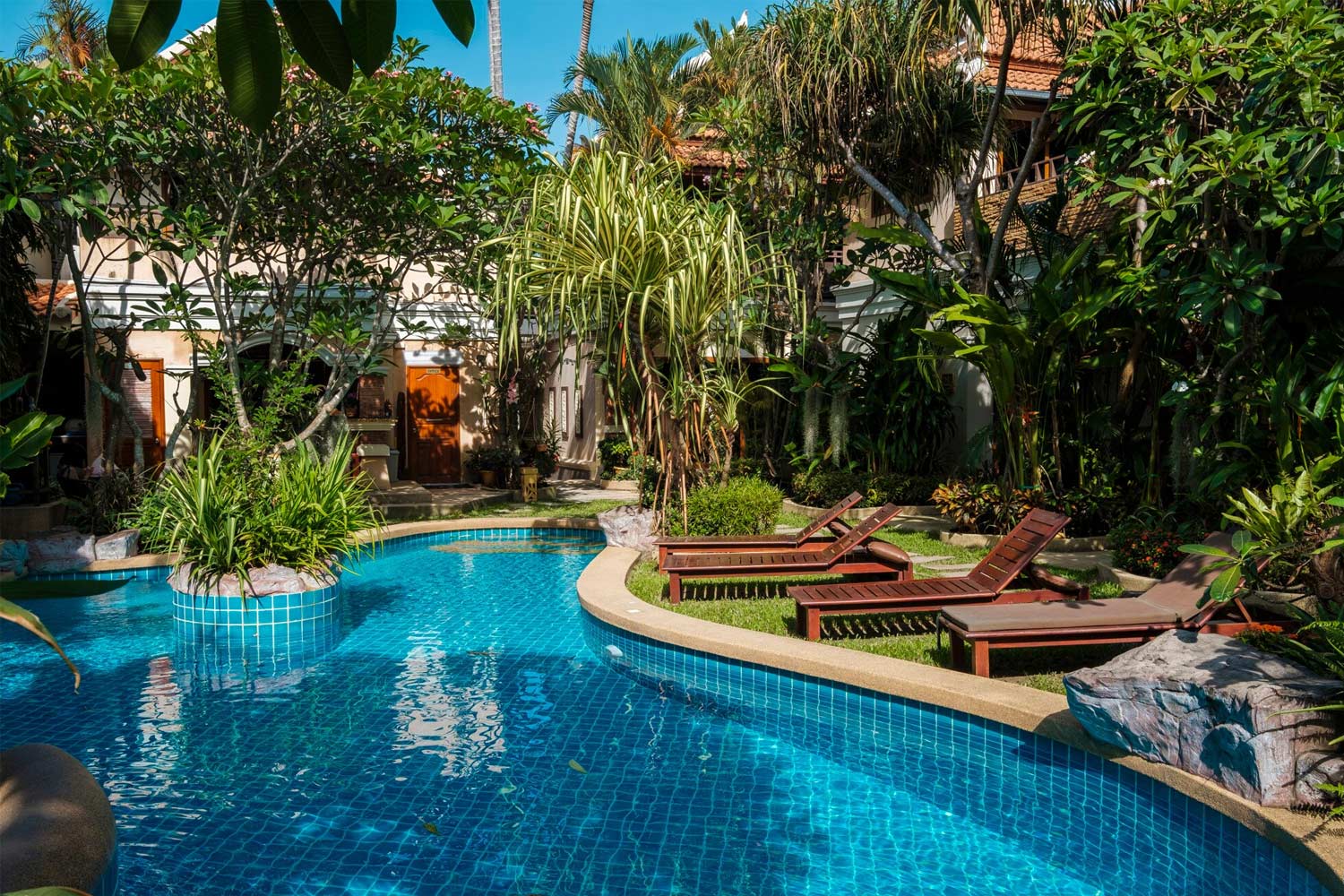 Piscina rodeada de jardines y espacios exteriores cuidadosamente planificados